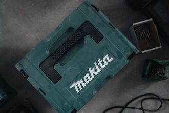 Ein ruhig arbeitender Makita Laubbläser liegt auf einer Wiese, umgeben von einem entspannten Hund und einer Katze, die sich nicht gestört fühlen.